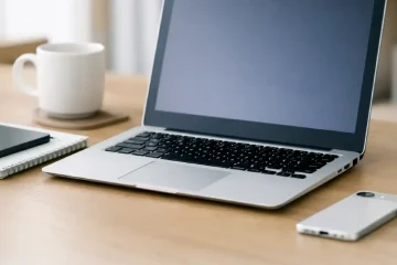 “Open laptop on a wooden desk with smartphone, notebook, and coffee mug — representing Primebyte Shop tech accessories for productivity.”